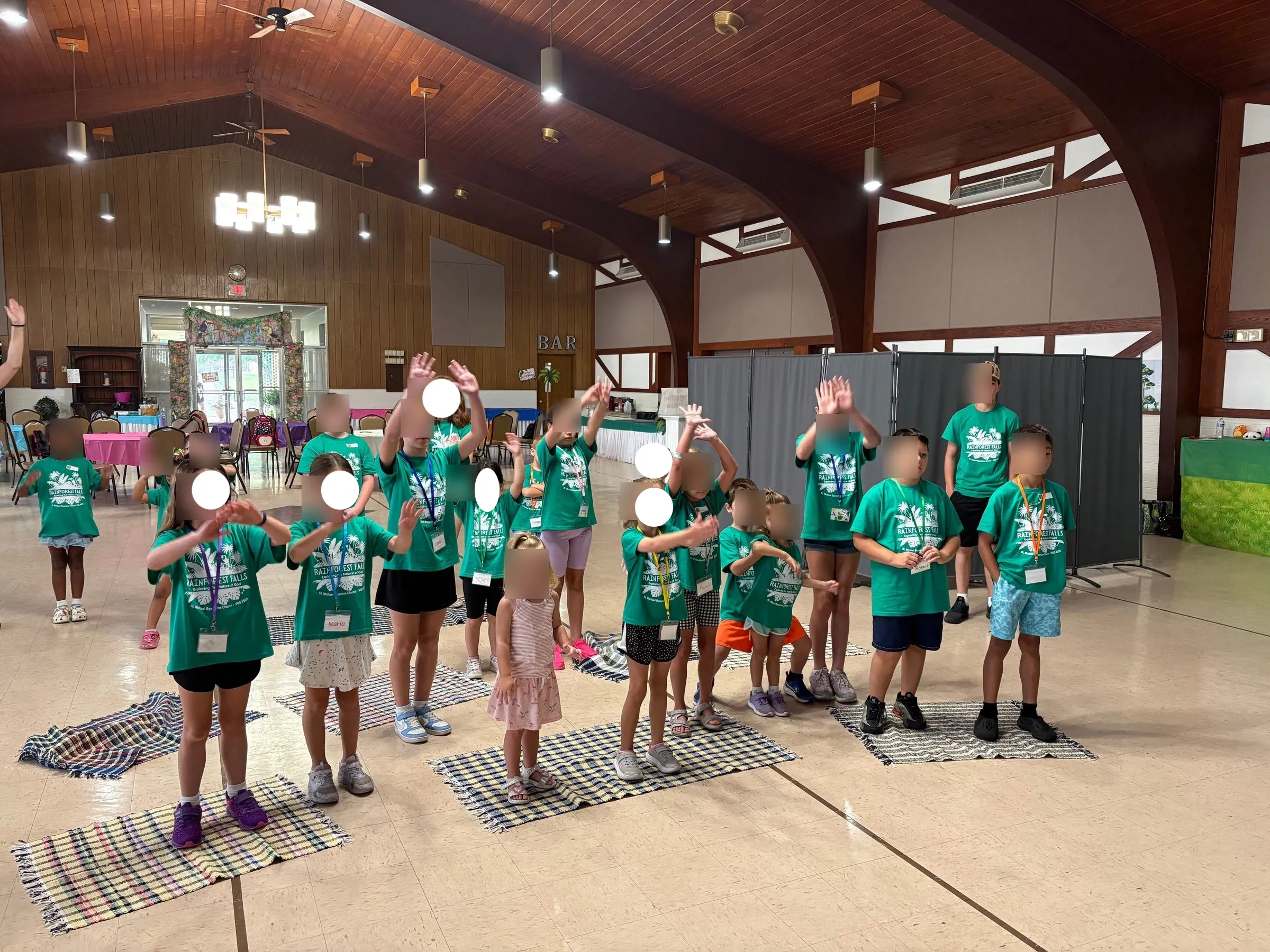 Children of Rainforest Falls VBS with their hands raised in song